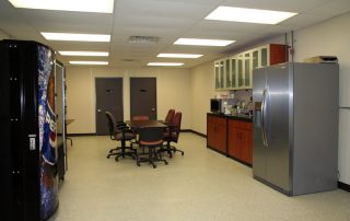 In-Plant Lunch Room In-Plant Lunch Room with vending machines, fridge, table, and chairs